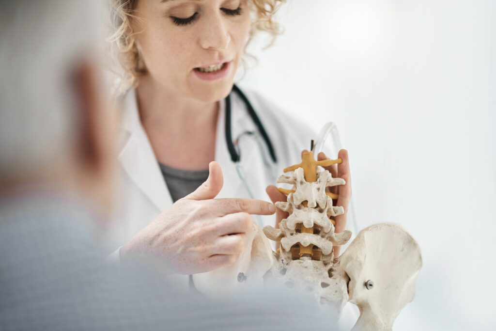 Cropped shot of an attractive young female chiropractor explaining her diagnosis to a male patient using a model skeleton